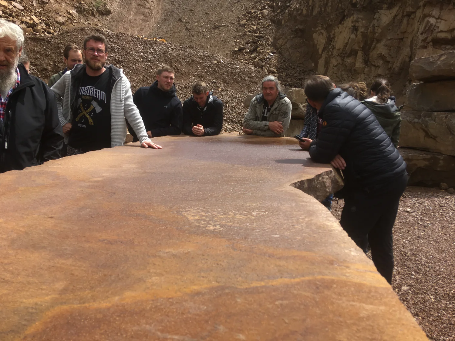 Michael Bottner with professionals around a large stone slab